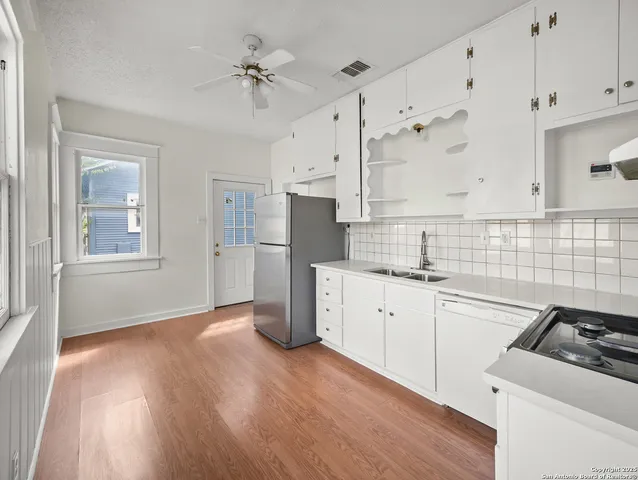 a kitchen with granite countertop a sink stove and refrigerator