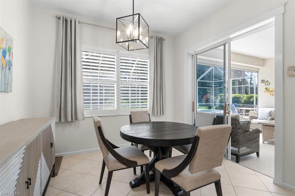 20117 Seadale Court Estero, FL 33928 - Photo 10 of 34 Tiled flooring with a geometric chandelier, plantation shutters, and sliding glass doors opening to a screened patio
