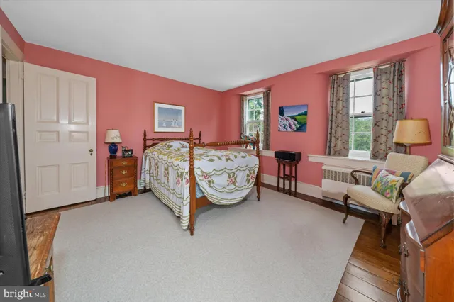 a room with a bed and a wooden floor