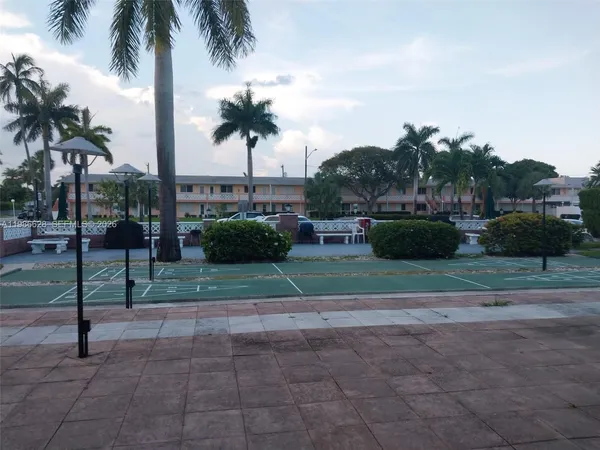 a front view of a house with garden and trees