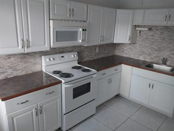 a view of a room with a chandelier fan