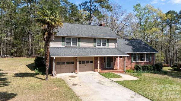a view of a house with a yard and sitting area
