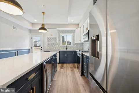 a open kitchen with stainless steel appliances granite countertop a sink a stove and refrigerator
