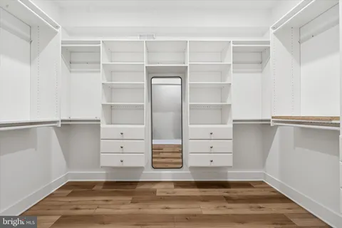 a view of walk in closet with empty racks