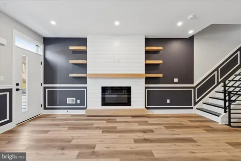 a view of an empty room with wooden cabinet and staircase
