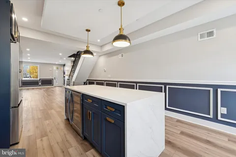a hallway with wooden cabinets and black stainless steel appliances
