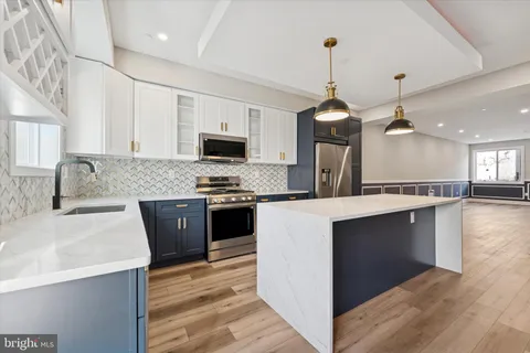 a kitchen with stainless steel appliances kitchen island granite countertop a sink stove and refrigerator
