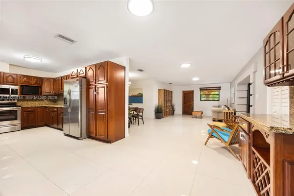 a kitchen with stainless steel appliances granite countertop a refrigerator and wooden cabinets