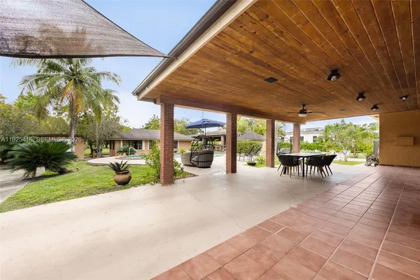 a view of a patio with table and chairs next to a yard