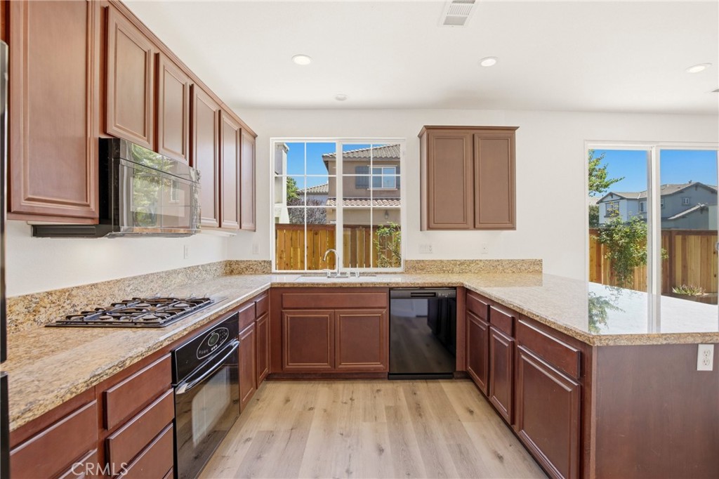 31598 Six Rivers Court Temecula, CA 92592 - Photo 18 of 43 a kitchen with stainless steel appliances granite countertop a sink stove and cabinets