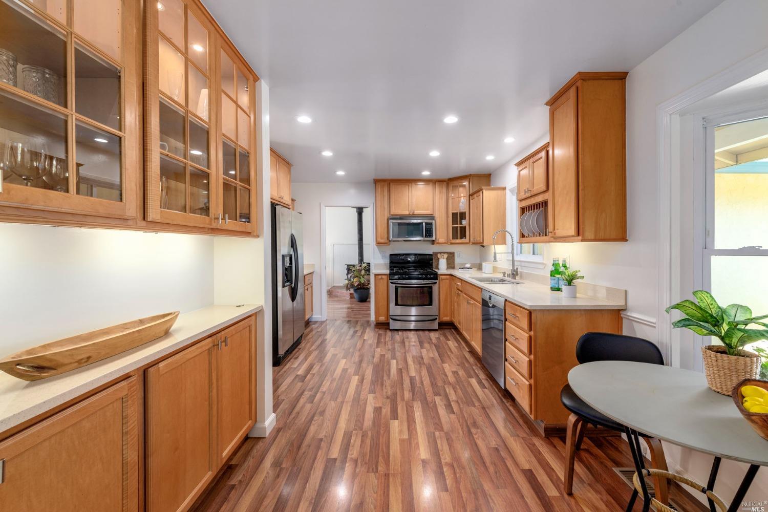 16 Loma Linda Road San Rafael, CA 94901 - Photo 14 of 46 a kitchen with stainless steel appliances a refrigerator a stove a sink dishwasher and a dining table with wooden floor