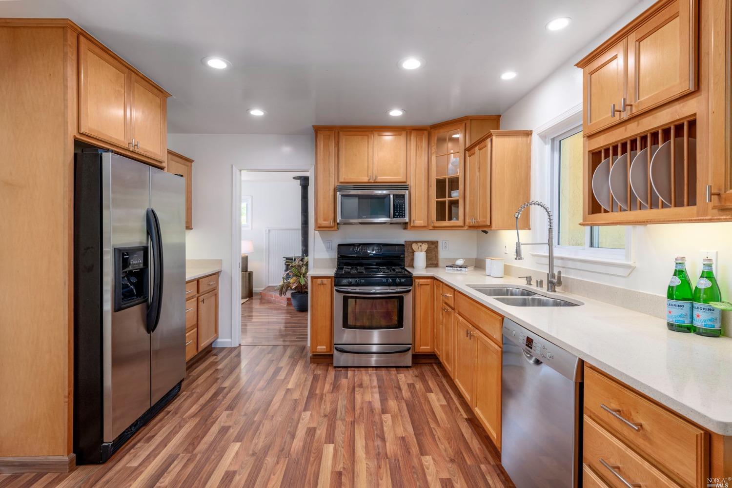 16 Loma Linda Road San Rafael, CA 94901 - Photo 18 of 46 a kitchen with stainless steel appliances granite countertop a refrigerator a sink dishwasher a oven with wooden cabinets and floor