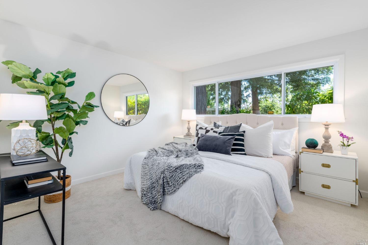 16 Loma Linda Road San Rafael, CA 94901 - Photo 30 of 46 a large bed sitting in a bedroom next to a window with a potted plant a couch and a potted plant