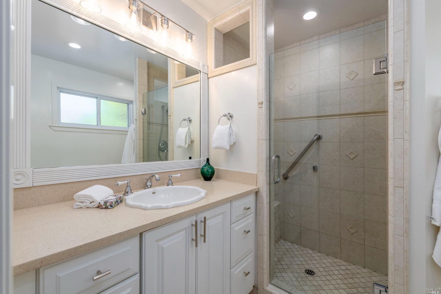 16 Loma Linda Road San Rafael, CA 94901 - Photo 31 of 46 a bathroom with a granite countertop sink a mirror and shower