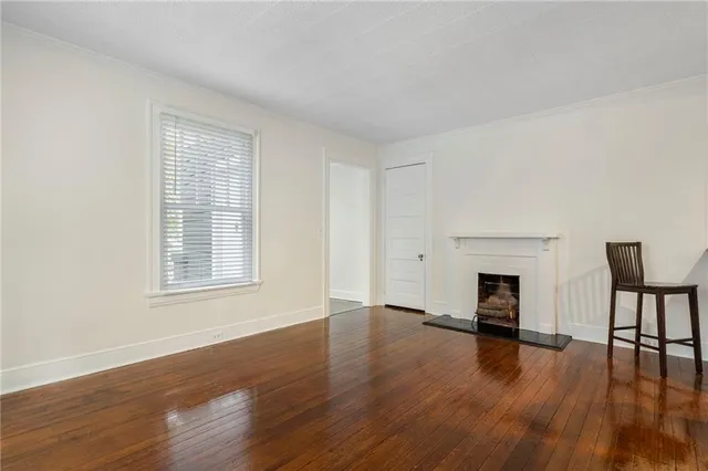 a view of empty room with wooden floor and fireplace
