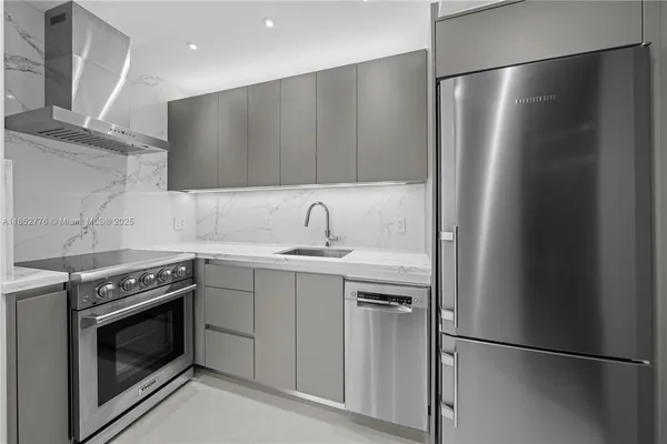 a kitchen with stainless steel appliances granite countertop a refrigerator a sink and a stove