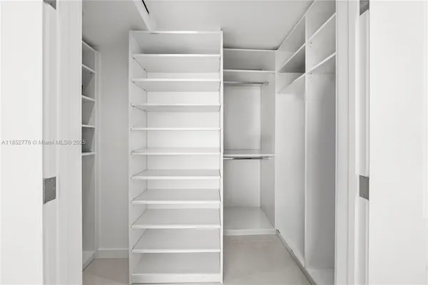 a view of walk in closet with empty racks
