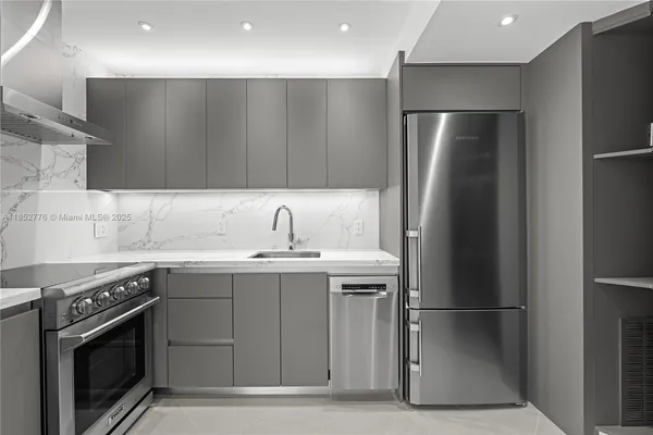 a kitchen with stainless steel appliances granite countertop a refrigerator a sink and a stove