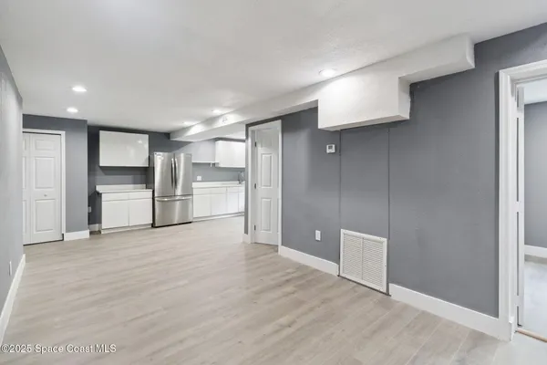a view of a kitchen with a refrigerator and a sink