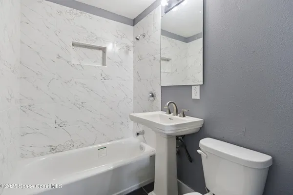 a bathroom with a sink a toilet and bathtub