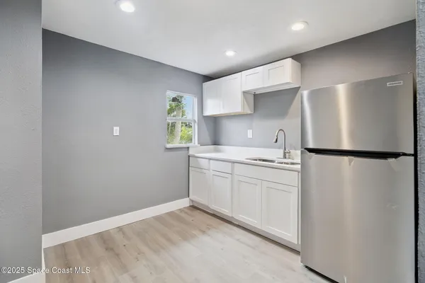 a kitchen with a refrigerator and a stove top oven