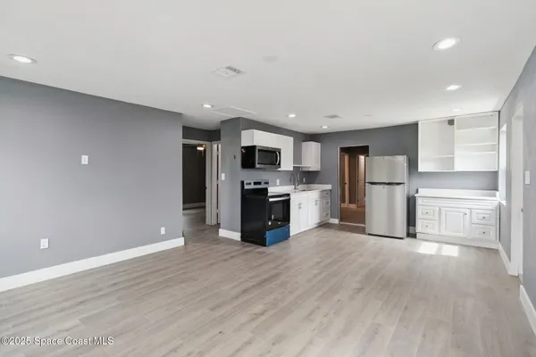 a kitchen with stainless steel appliances a refrigerator sink and microwave