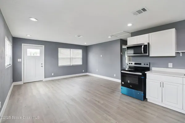 a kitchen with granite countertop a stove a sink and a microwave