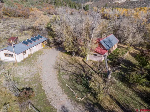 an aerial view of a house with a yard and large trees