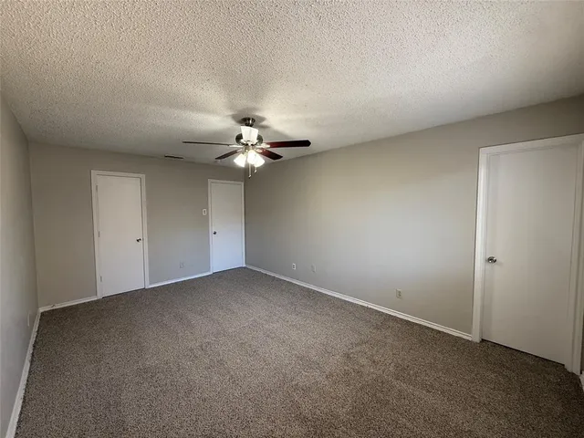 a view of an empty room with a chandelier fan