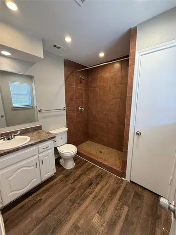 a bathroom with a granite countertop sink toilet and shower