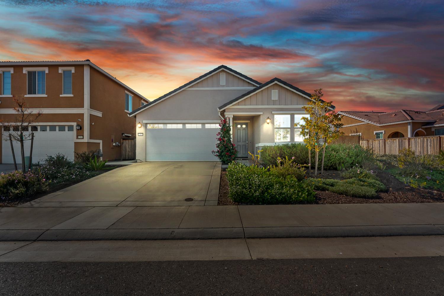 a front view of a house with a yard and potted plants