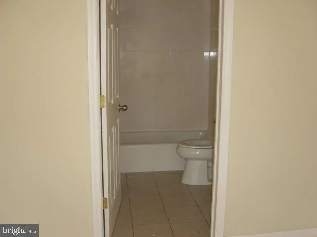 a bathroom with a granite countertop toilet and a shower