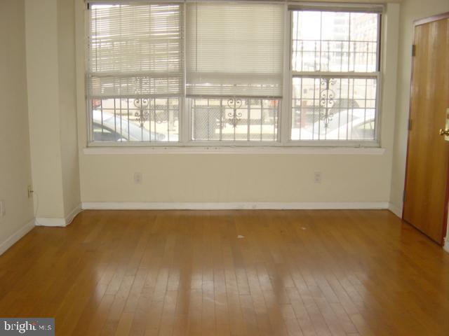 1121 Hamilton Street, Unit A Philadelphia, PA 19123 - Photo 8 of 11 a view of an empty room with wooden floor and a window