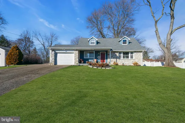 a front view of a house with a garden and trees