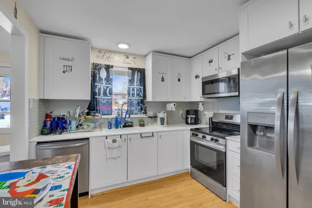 a kitchen with white cabinets sink and stainless steel appliances