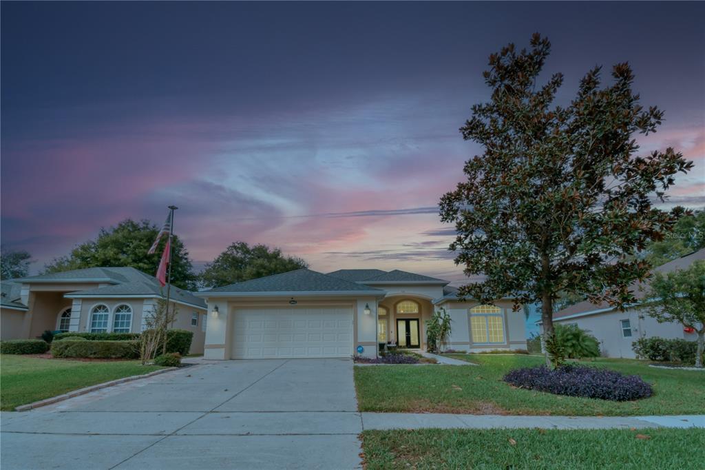 3862 Beacon Ridge Way Clermont, FL 34711 - Photo 48 of 56 a front view of a house with a yard and garage