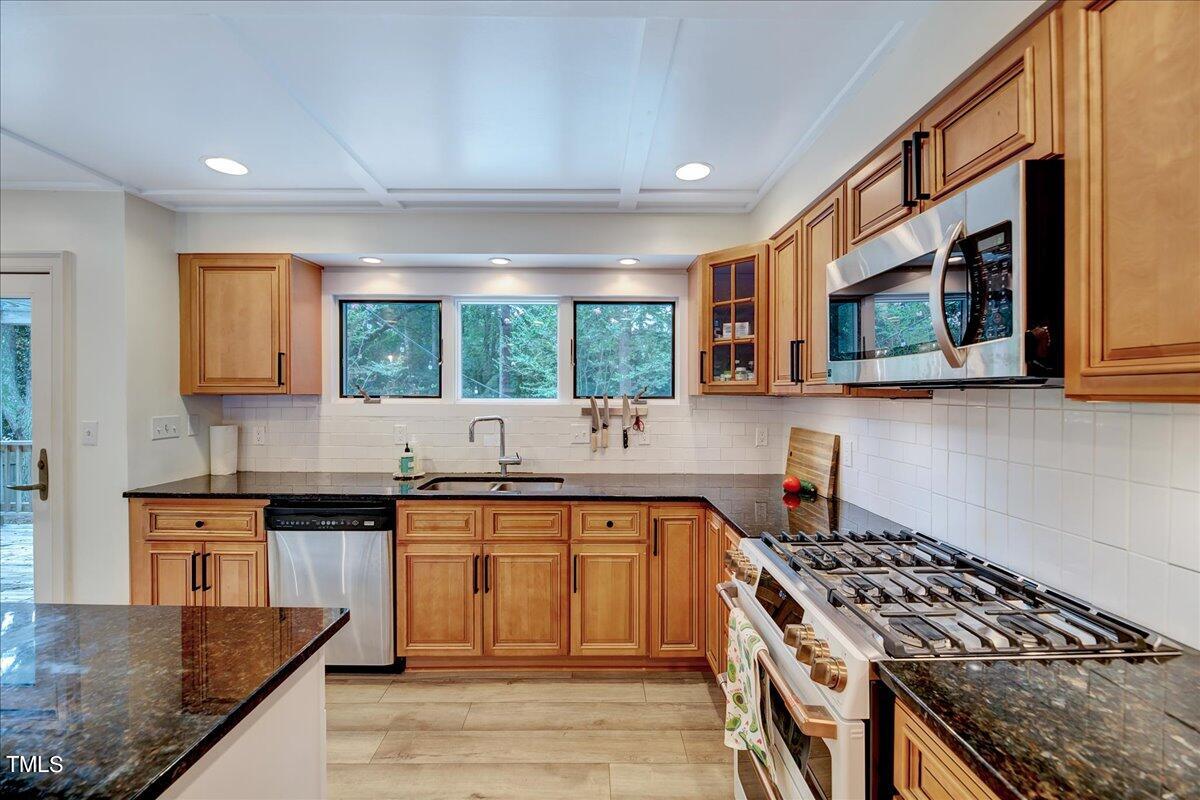 11001 Honeycutt Road Raleigh, NC 27614 - Photo 11 of 36 a kitchen with stainless steel appliances granite countertop a stove a sink and a microwave