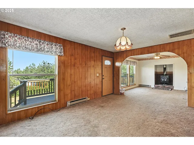 a view of an empty room with closet and a window
