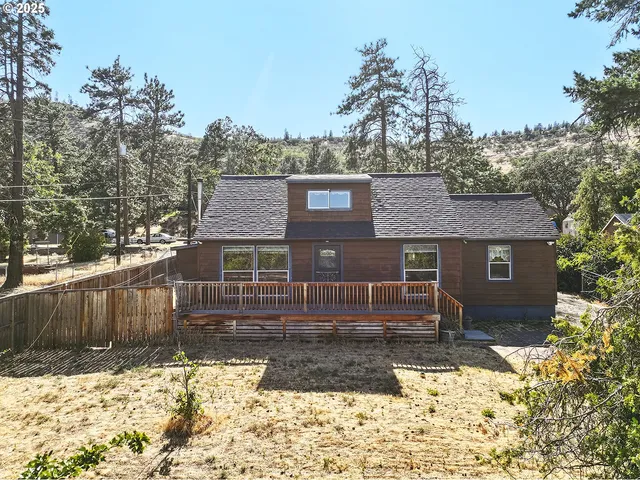 a front view of a house with a yard covered with snow