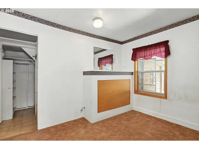 an empty room with windows and a ceiling fan