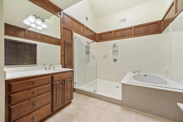 a bathroom with a tub a sink and mirror