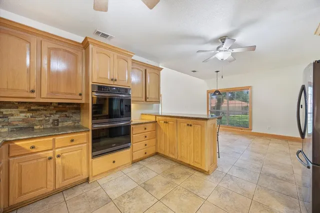 a kitchen with stainless steel appliances granite countertop a refrigerator and a stove top oven
