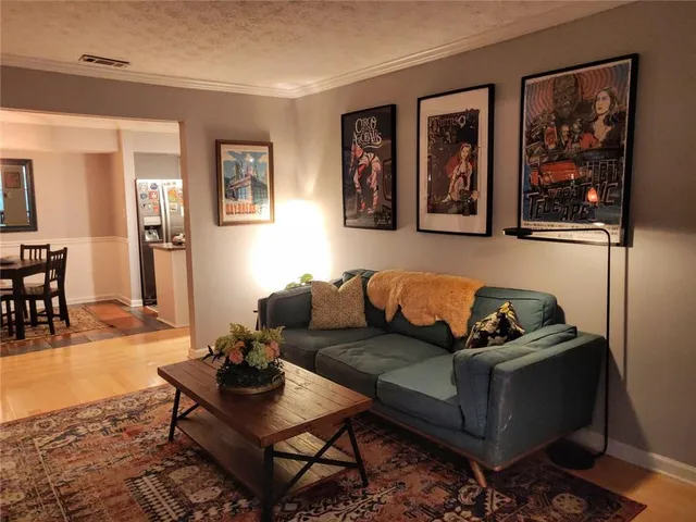 a living room with furniture and wooden floor