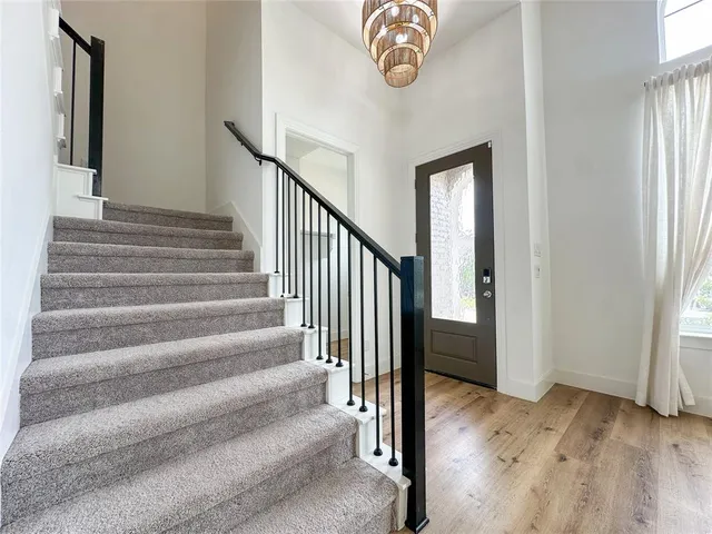 a view of a hallway with wooden floor and entryway