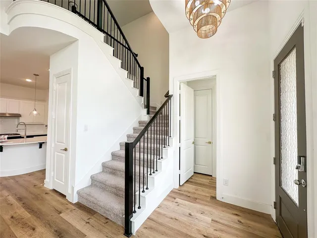a view of a hallway with wooden floor and staircase