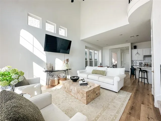 a living room with furniture a flat screen tv and a floor to ceiling window