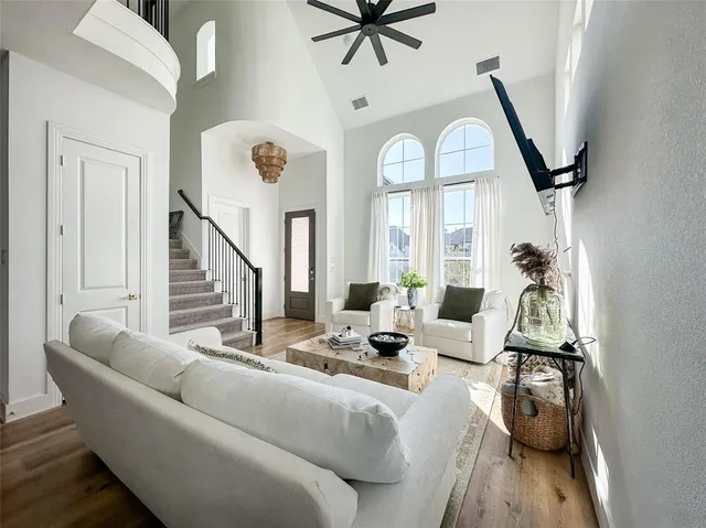 a living room with furniture a flat screen tv and a large window