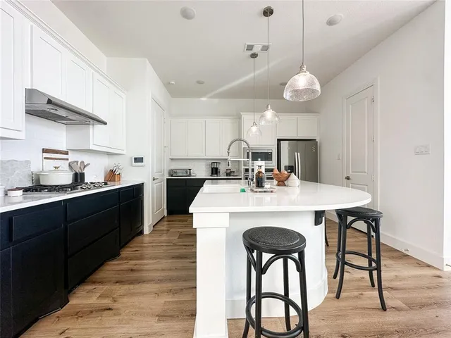 a large kitchen with cabinets and wooden floor
