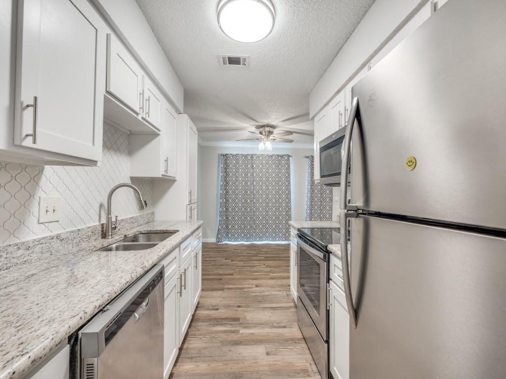 649 Timberline Drive Hurst, TX 76053 - Photo 14 of 29 a kitchen with granite countertop a refrigerator and a sink