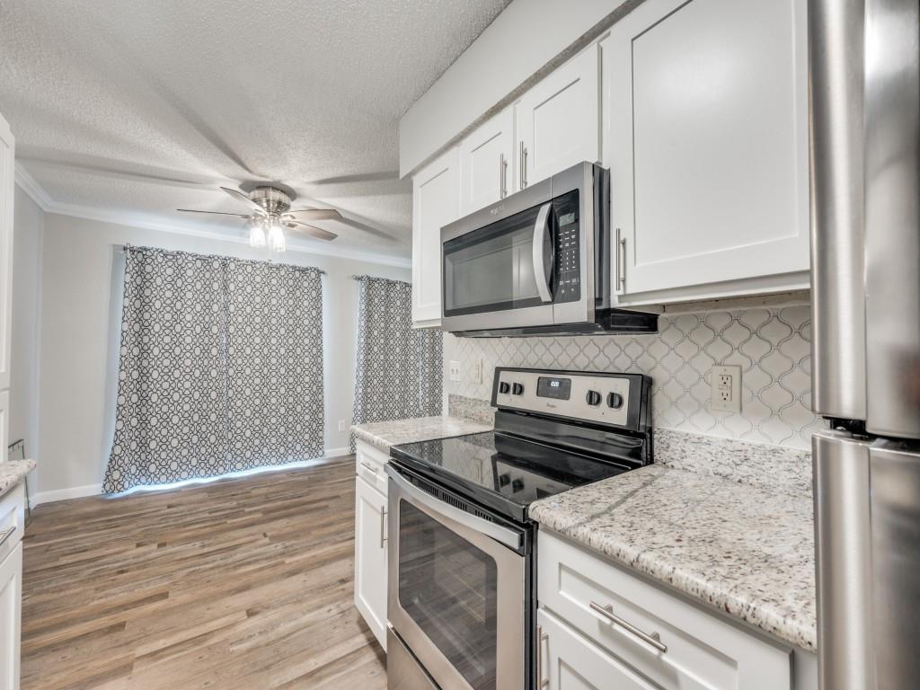 649 Timberline Drive Hurst, TX 76053 - Photo 15 of 29 a kitchen with stainless steel appliances granite countertop a sink stove and microwave